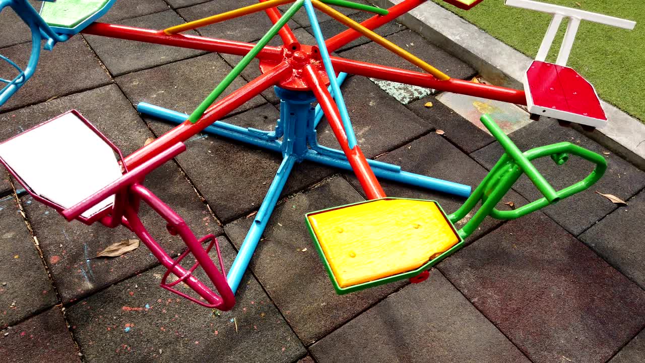 Self Propelled merry go round spinning on empty playground in the summer park.