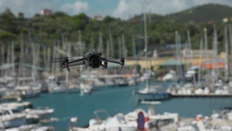 Flying-DJI-Mavic-3-Pro-drone-with-boats-in-blurred-background-and-cityscape