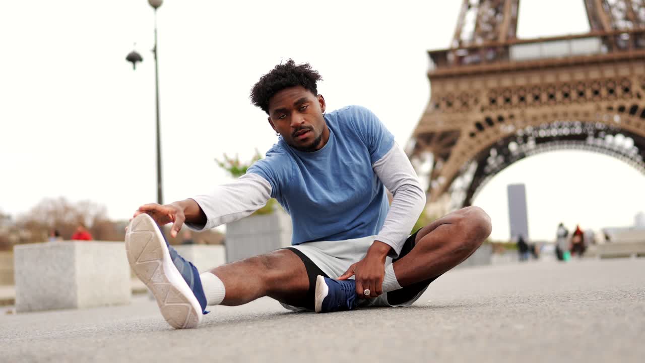 Man stretching in front of the Eiffel Tower