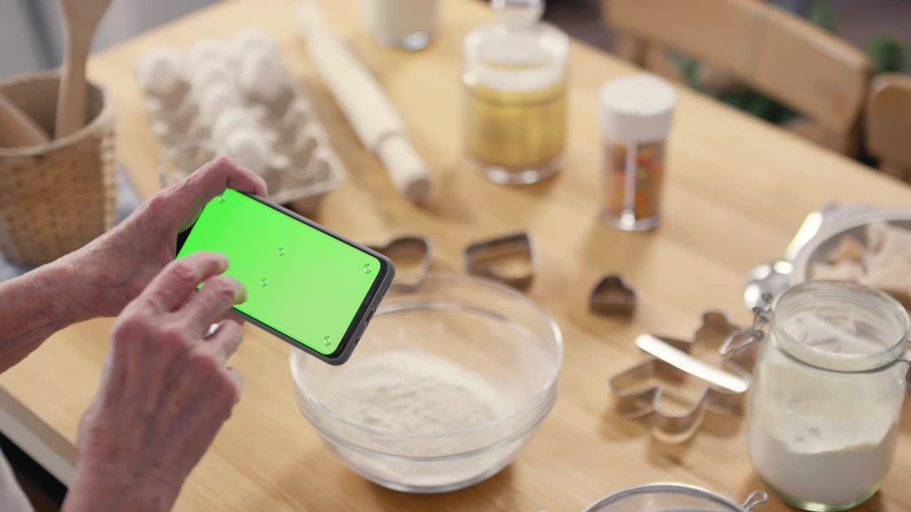 초록색 화면 을 가진 휴대 전화 를 사용하는 노인 여자