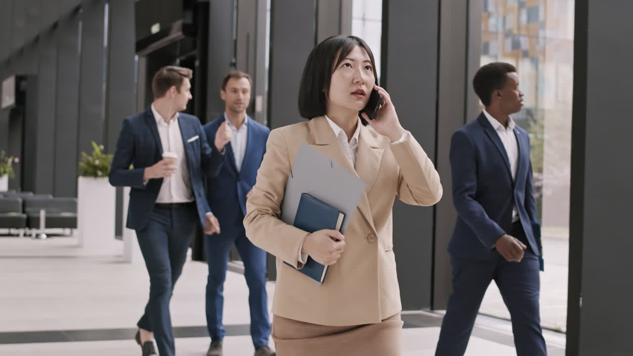 아름다운 아시아 사업가 여성이 전화를 하고 있습니다.