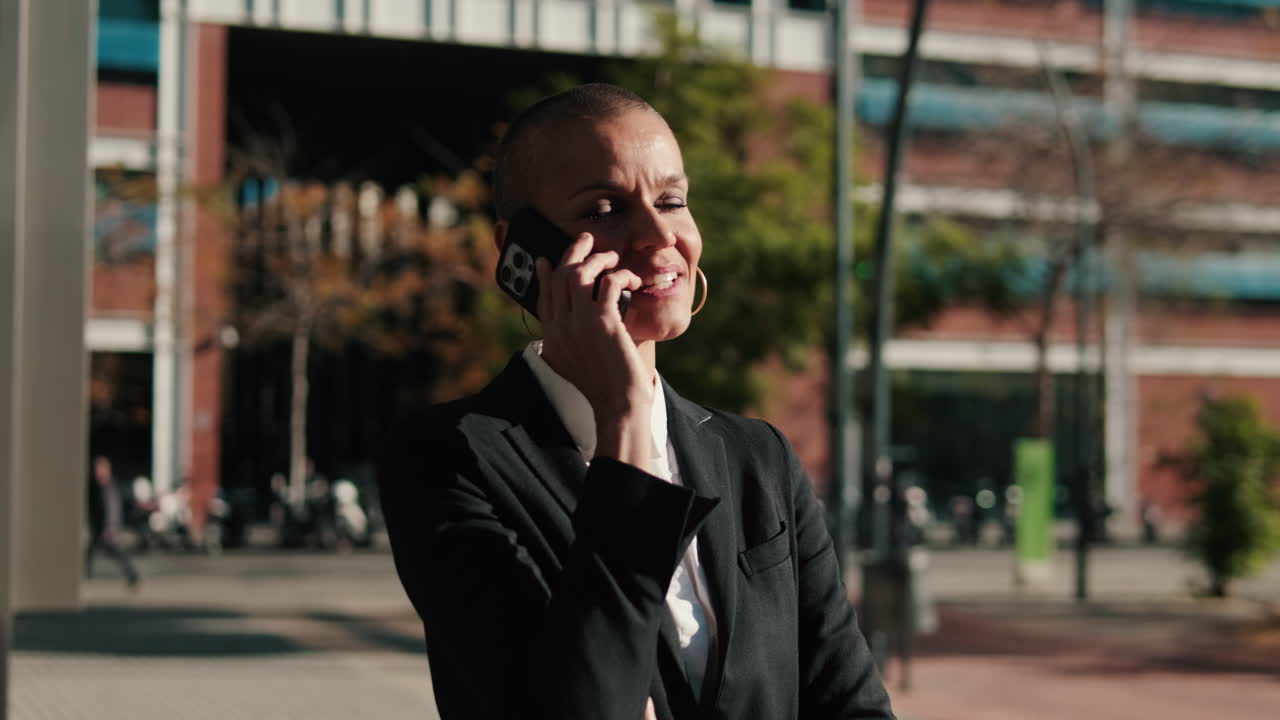 Empresária sorridente falando ao celular na rua da cidade