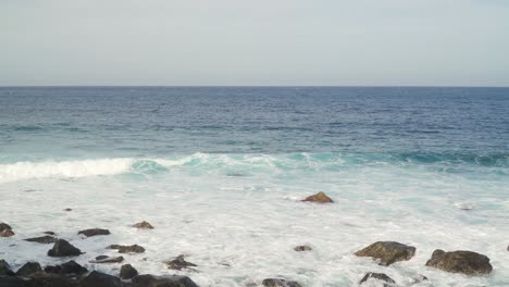 atlantic ocean waves crushing into the stone beaches of madeira island, portugal.