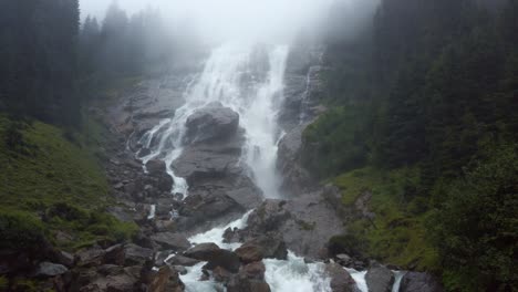 tiro inclinado de la cascada grawa en un día nublado y lluvioso en el valle de stubai, tirol, austria