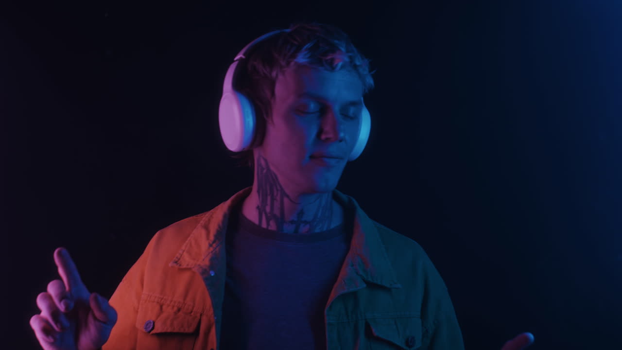 Young Caucasian Guy in Headphones Visiting Nightclub