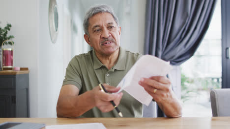 retrato de un anciano biracial haciendo una llamada de video