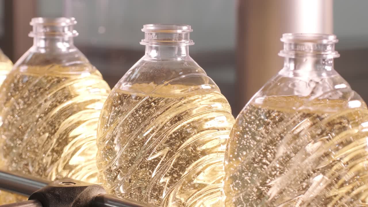 생산 라인에서 움직이는 병에 있는 해바라기 기름. 병에 담긴 해바라지 기름을 병에 담는 라인. 식물성 기름 생산 공장. 첨단 기술. 산업적 배경