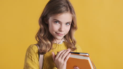 happy teenage caucasian girl student holding notebooks and making funny faces.