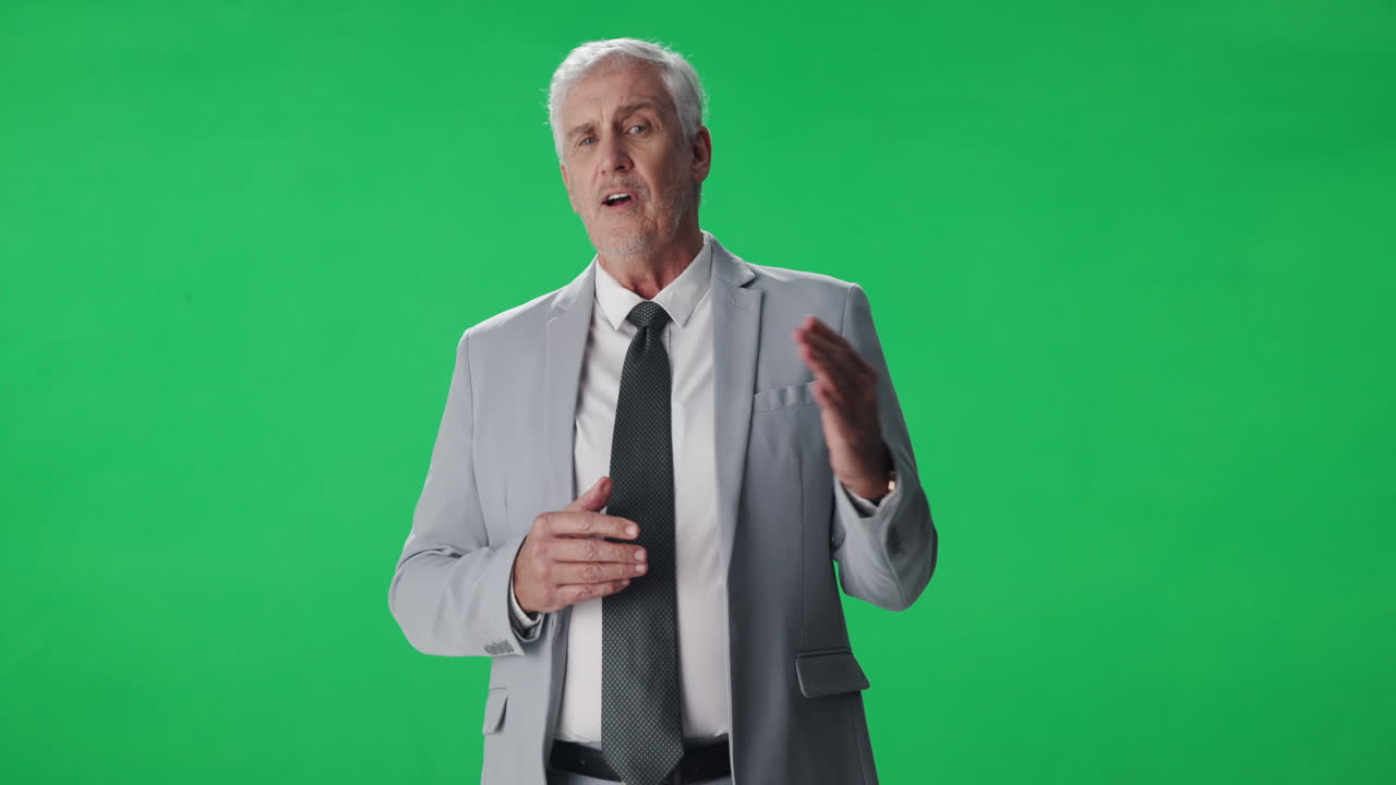 Mature man in suit presenting on green screen