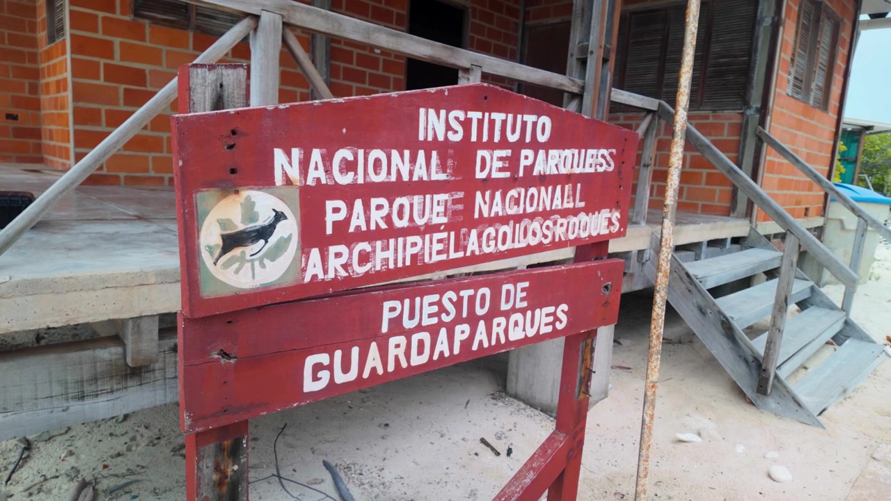 Cartello della stazione dei ranger del parco a Dos Mosquises nel Parco Nazionale Los Roques, come sfondo medio di ambientazione