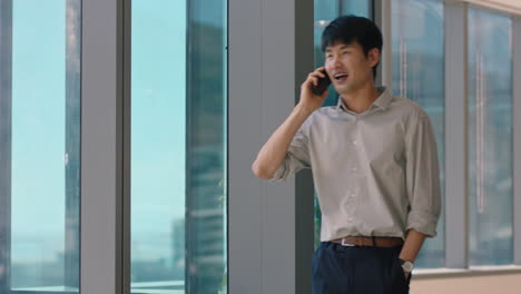 asian businessman using smartphone chatting to client financial advisor negotiating business deal corporate sales executive sharing expert advice having phone call in office looking out window