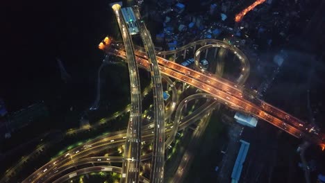 Glowing-traffic-lights,-high-up-aerial-shot-of-the-highway-intersection-of-Chongqing,-Huangjuewan,-China