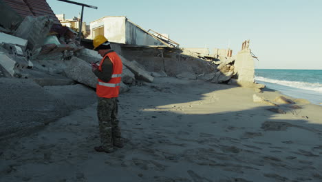 experienced engineer inspecting a collapsed building near the sea