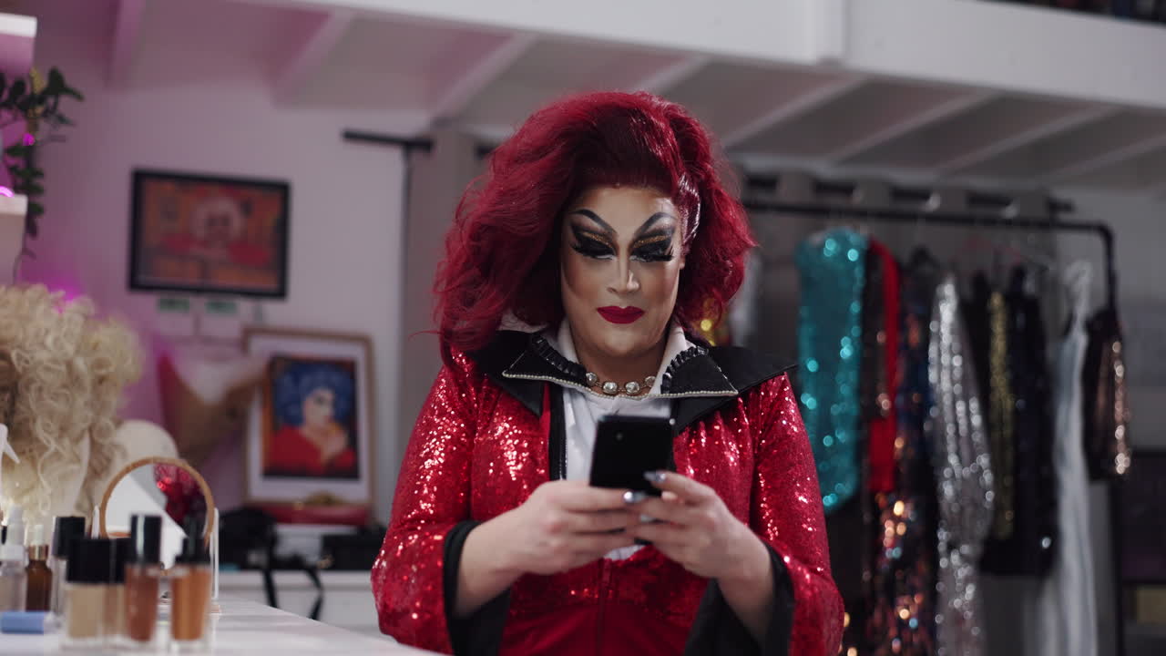 Drag queen in dressing room using mobile phone