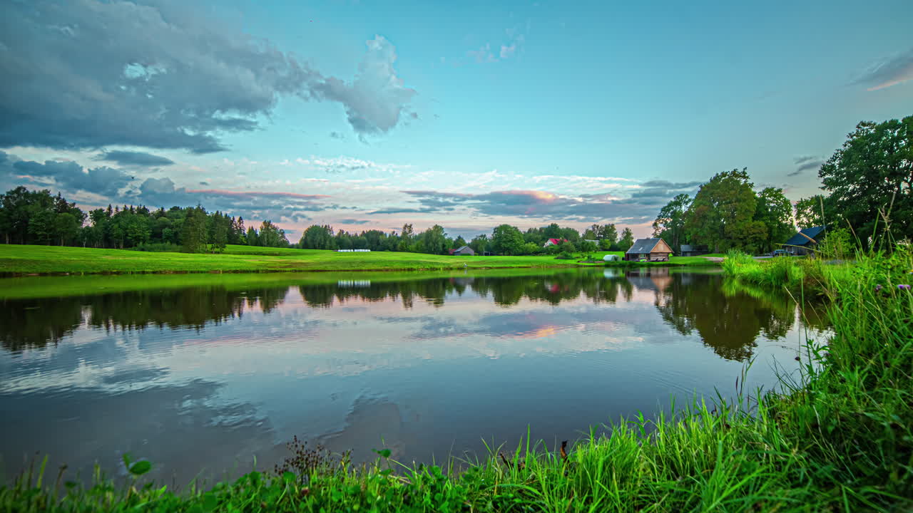 여름 아침 해가 뜨는 동안 라트비아의 시골 풍경에서 호수를 내려다보는 풍경적 인 타임  ⁇ 스