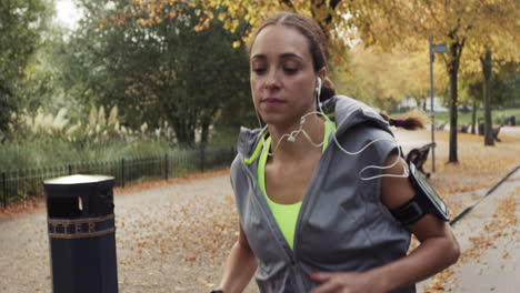 runner woman running in park exercising outdoors fitness tracker wearable technology