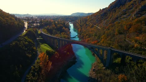 Stunning-aerial-4K-drone-footage-of-Solkan-arch-bridge-over-the-Soča-river,-a-majestic-stone-marvel-located-in-western-Slovenia