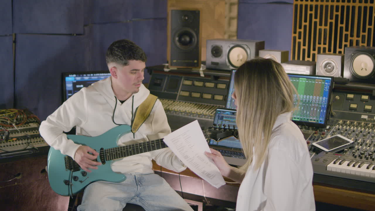 새로운 노래를 녹음하는 동안 음악 스튜디오에서 일하는 두 명의 음악가