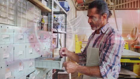 animation of blinking eye over caucasian male carpenter working in workshop