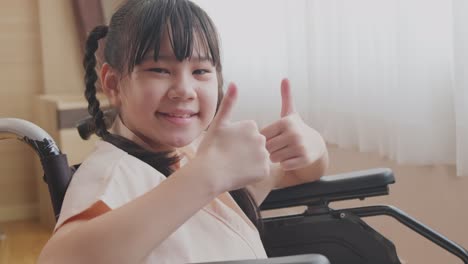 smiling girl in wheelchair giving thumbs up