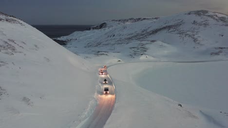 A-convoy-of-cars-going-towards-the-most-Northern-part-of-Europe,-the-Nordkapp,-during-a-cold-and-dark-winter-day