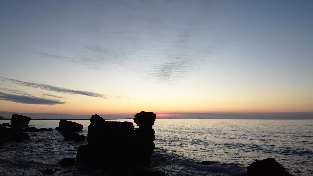 Sunrise over the Ocean with Silhouetted Rocks