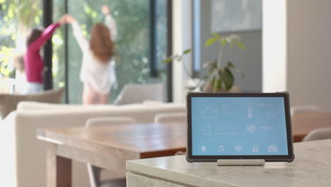 smart home tablet on kitchen counter with lesbian couple in background, copy space