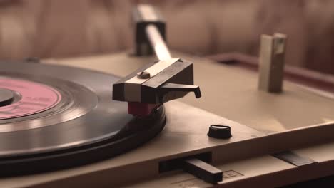 starting playing vinyl record on vintage gramophone, placing needle, close up