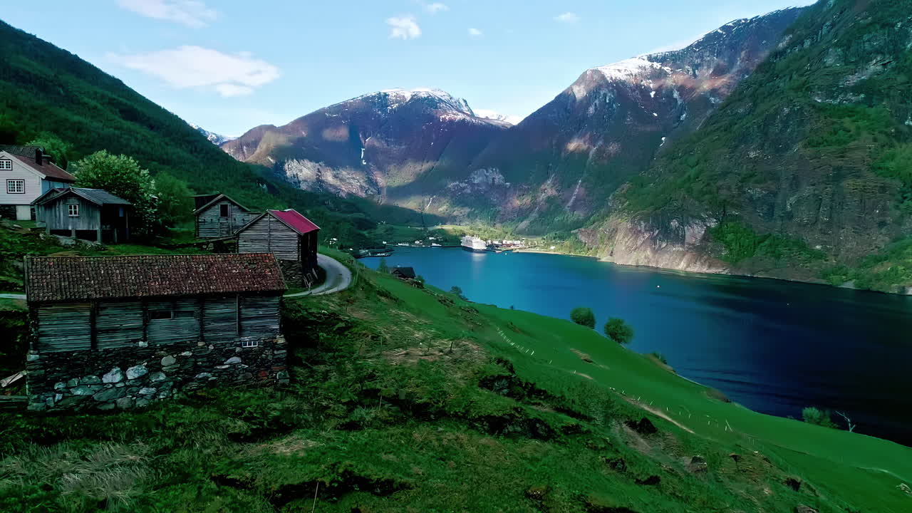 Vista aerea del villaggio di Flam, Norvegia: costa del fiordo, montagne, valle, cime innevate, natura.