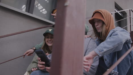 friends using smartphone on the stairs