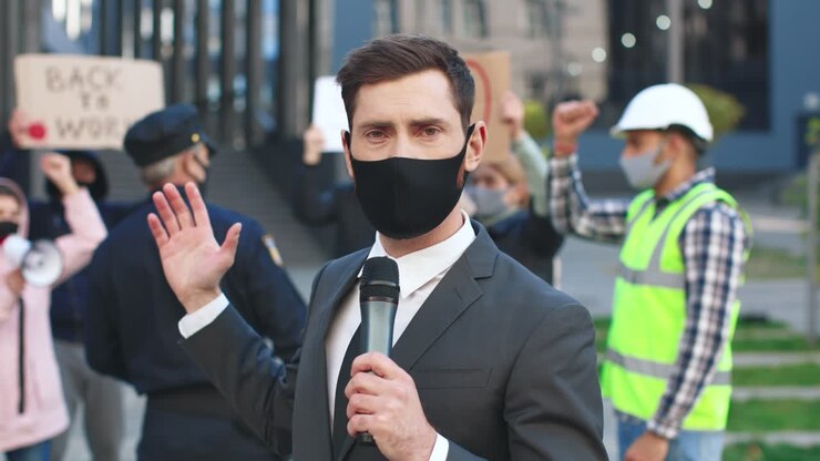 Close-up view of caucasian journalist or correspondent wearing protective mask giving interview in a protest against Covid 19