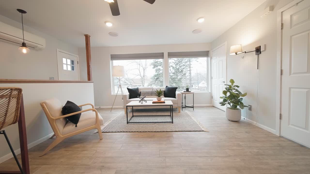 sala de estar luminosa con muebles de diseño moderno en una casa diminuta con una ventana grande