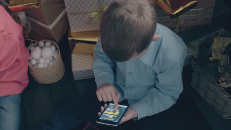 un niño con camisa azul juega juegos móviles en un teléfono inteligente