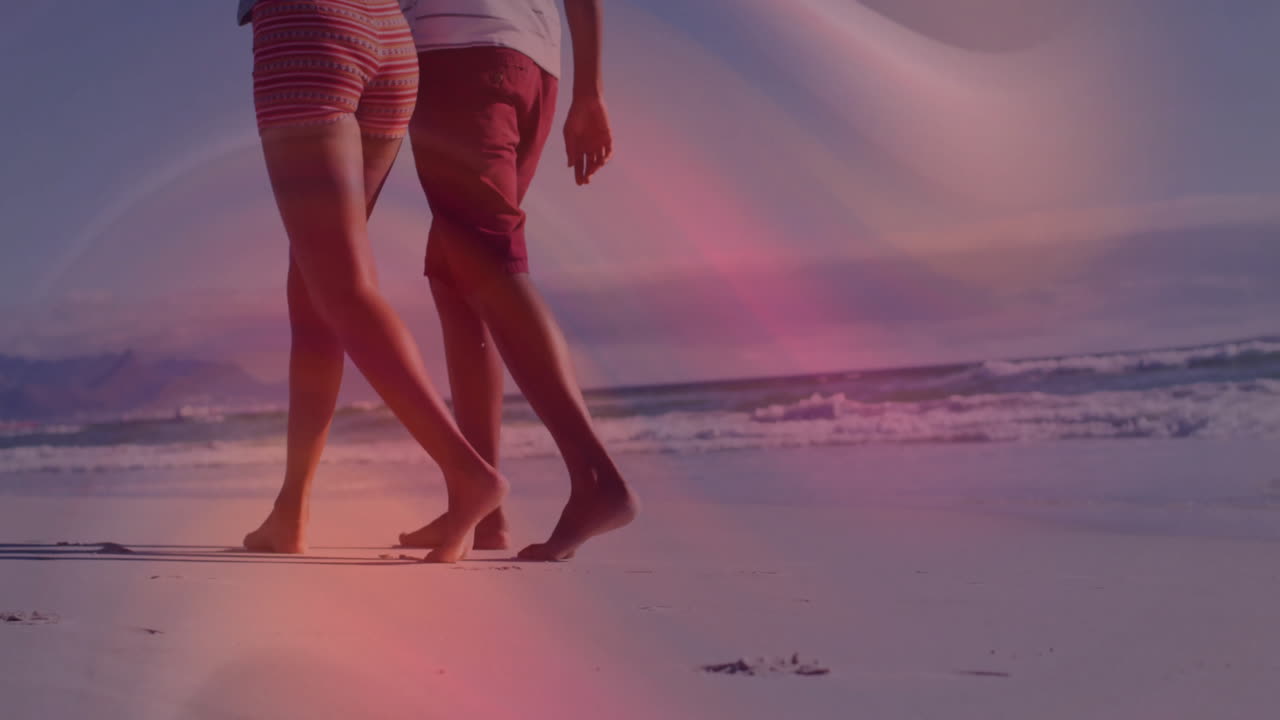 Walking barefoot on beach, couple enjoying colorful animation light effects
