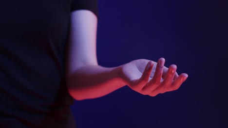 hand of asian woman, touching virtual screen on blue background, copy space, slow motion