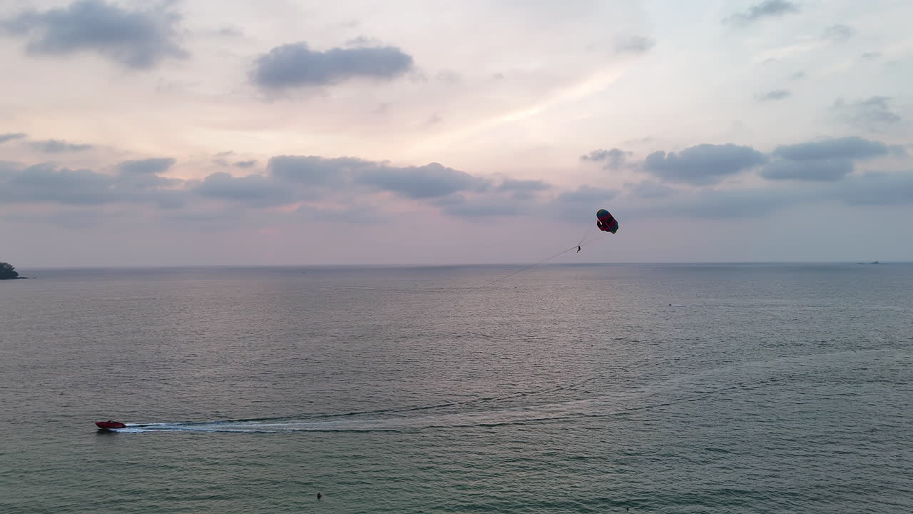 Paragliding on coast of Thailand at sunset over the ocean