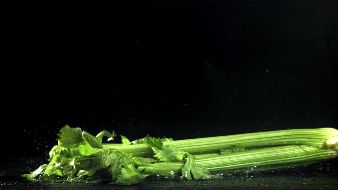 Slow Motion of Fresh Celery Falling and Splashing Water