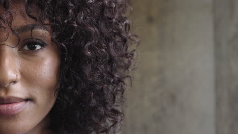 portrait of attractive african american woman smiling looking at camera black female beauty on wooden background half face