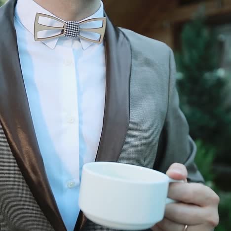 man with tea cup outdoors