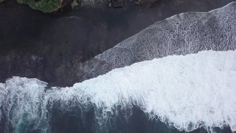 aerial drone view of cliff overgrown by tress border with the sea