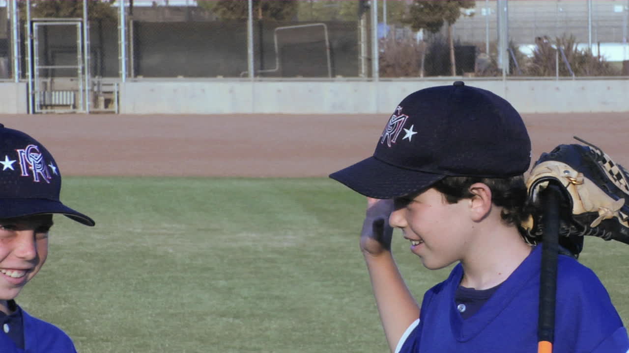 los jugadores de béisbol juvenil de la liga pequeña se dan apretones de manos