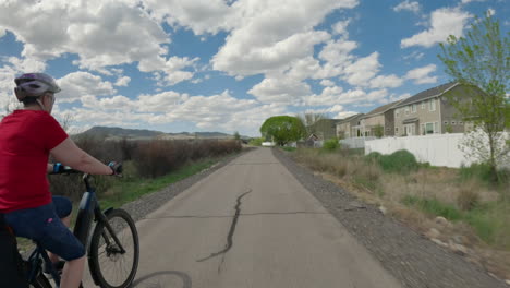 Senior-woman-with-an-active-lifestyle-riding-an-electric-bicycle-along-a-nature-trail