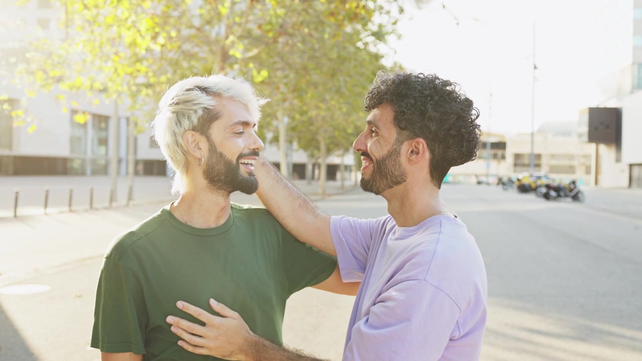 Coppia gay affettuosa e sorridente in un contesto urbano