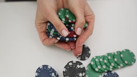 close-up of hands holding and dropping colorful poker chips
