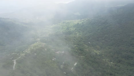 Drone-shot-high-in-the-clouds-revealing-the-valley-of-the-Sierra-Nevada,-Colombia