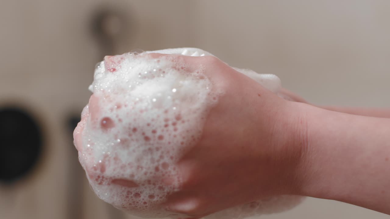 ducha exfoliar esponja de baño en las manos de una mujer