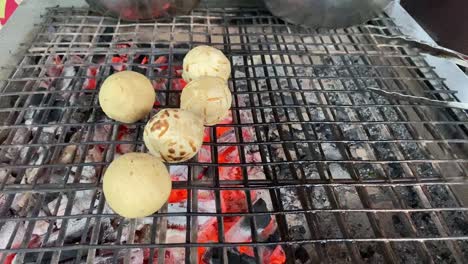 Litti-or-Litthi-chokha-being-prepared-on-an-iron-grill,-barbecue-in-Bihar