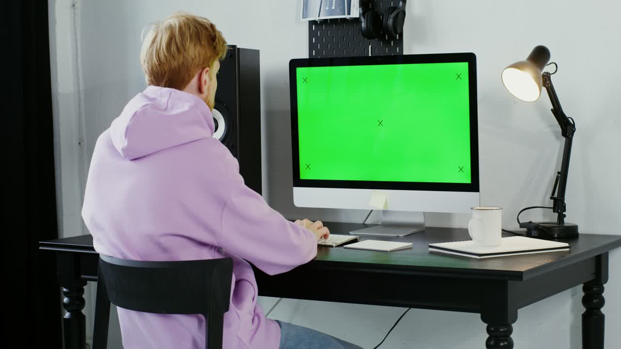 persona que trabaja en una computadora con pantalla verde