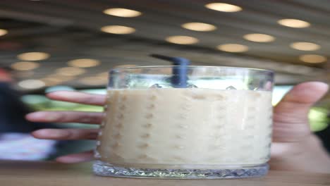 mujer bebiendo café helado en una cafetería