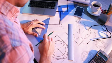Male-architect-working-on-blueprint-at-his-desk-4k